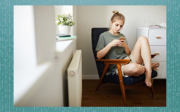 Woman sitting in a chair looking at her phone