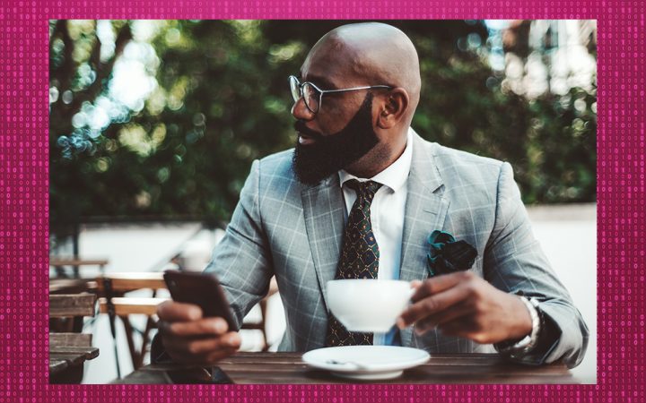 Man sitting at table with his phone and a mug