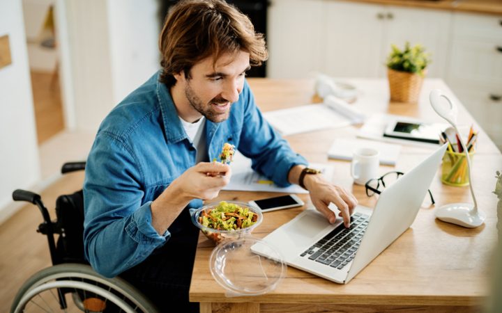 Man eating his lunch in front of laptop screen