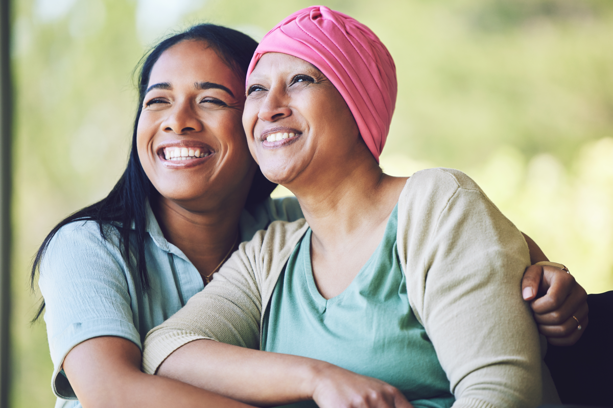 Love, bonding and woman with her mom with cancer hugging, sitting and spending time together. Happy, sweet and sick mature female person embracing her adult daughter with a smile in outdoor garden