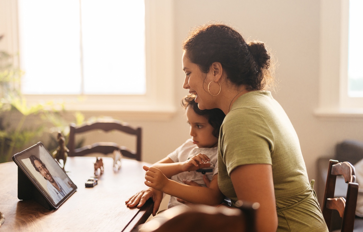 Young mother getting good news from her family doctor on a video call. Mother and son having an online consultation with their paediatrician. Loving young mother caring for her son at home.